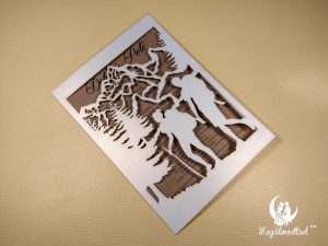 Túrázó páros lézervágott esküvői meghívó erdő és hegyek mintával