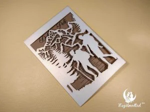 Túrázó páros lézervágott esküvői meghívó erdő és hegyek mintával